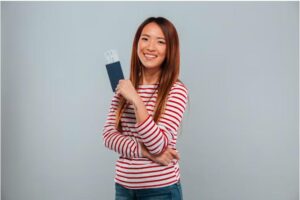 Female Asian immigrant holding her visa