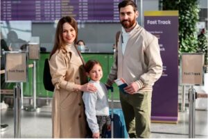 A mother, father, and daughter at the airport while holding a family visa